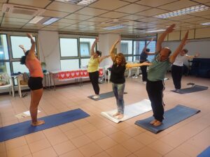 Personas practicando Hatha Yoga Adaptado durante la primera sesión organizada por ADISHREC en la sala polivalente de la ONCE, Las Palmas de Gran Canaria.